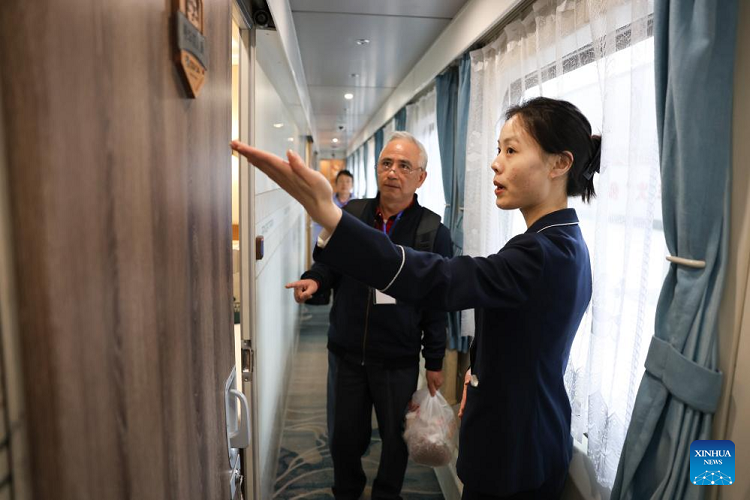 Attendant helping a passenger board the Panda Train at Guiyang on 8 May 2024